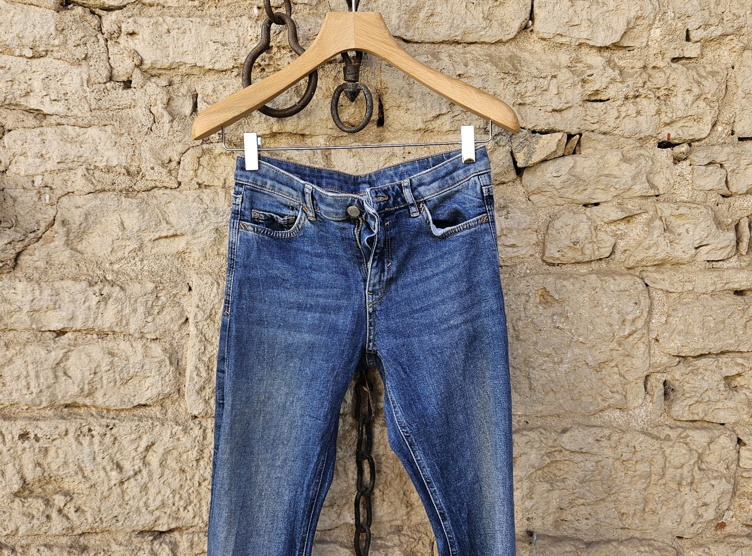 dunkelblaue Jeanshose vor Natursteinwand