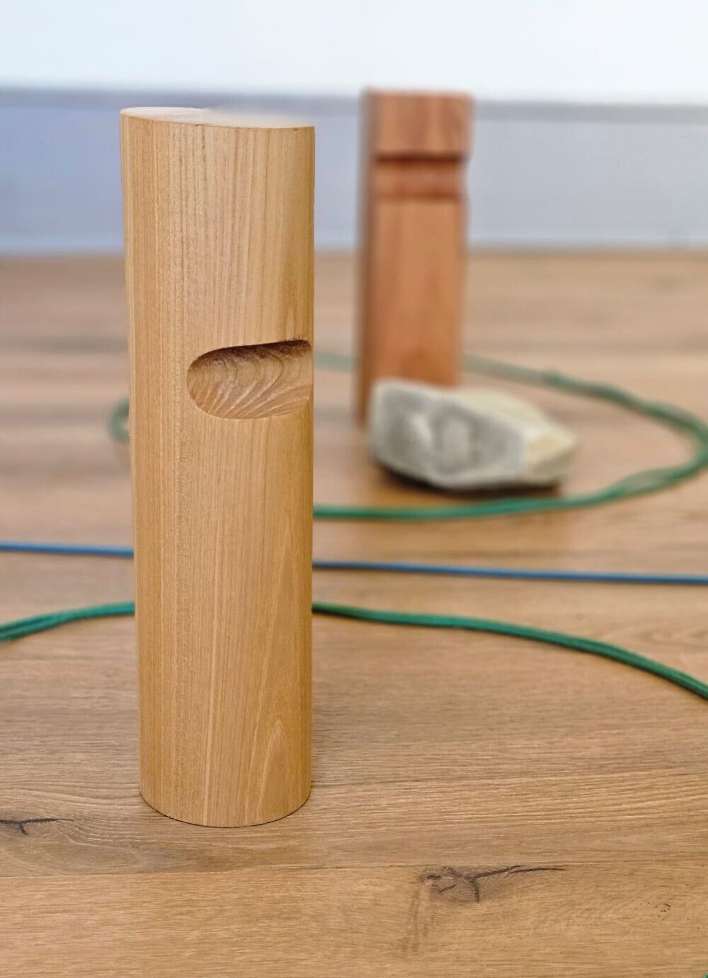 Familienaufstellung mit Holzfiguren als Bodenankern mit Grenze, Räumen, Booten, die durch Seile dargestellt sind und Stein für die Rückgabe